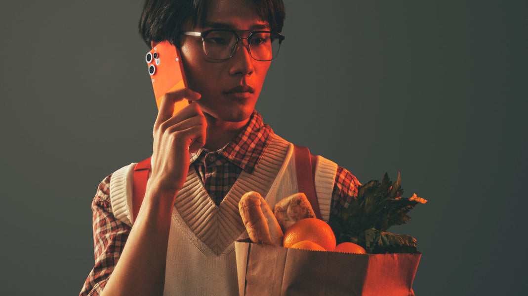 a man holding a bag of food and talking on a cell phone